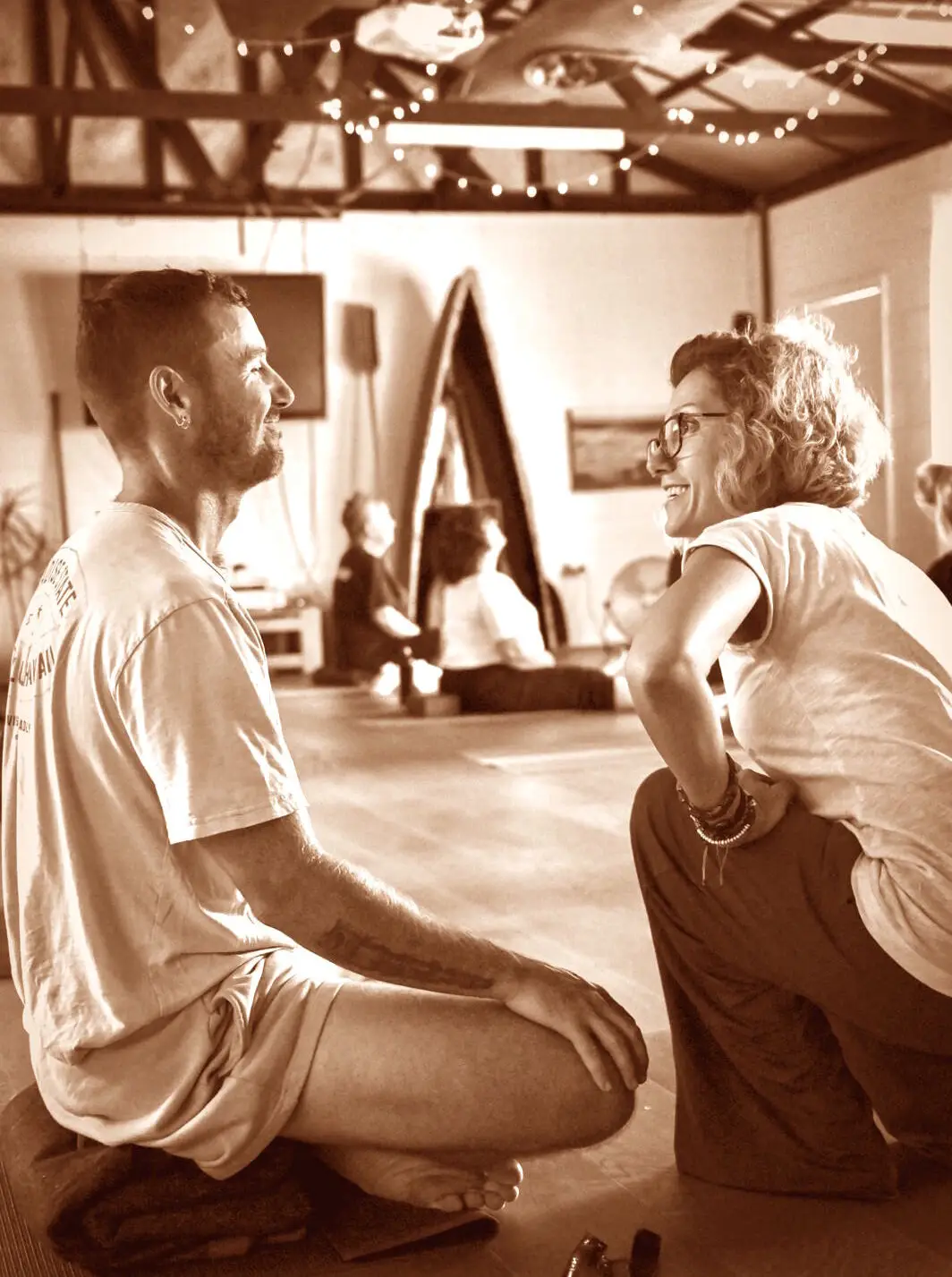 Yoga teacher Stanja seated in casual post-class conversation with a participant, reflecting the warm, inclusive community at her Marrickville studio.